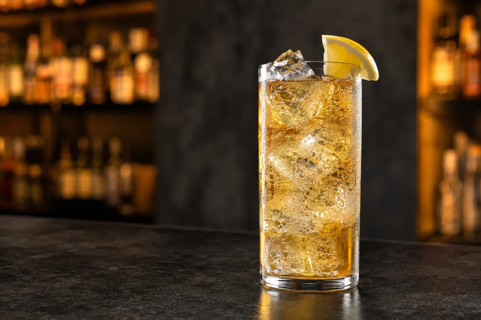 Golden Whisky Ginger over ice with bubbles and a lemon wedge